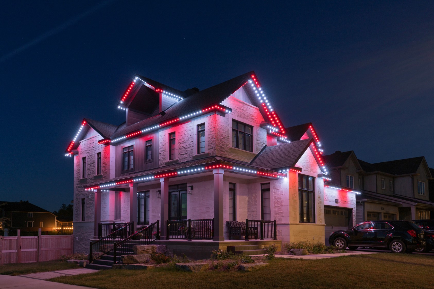 Permanent red and white candy-cane Christmas lights on a home roofline