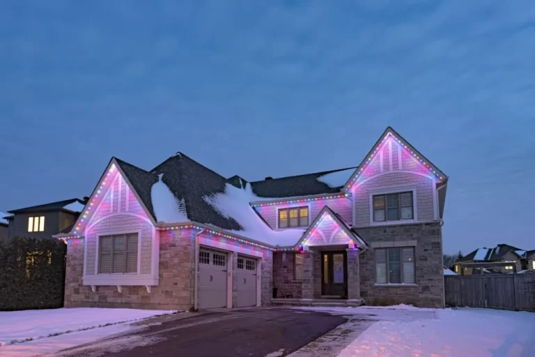 Colorful lighting outlines snowy house during winter evening