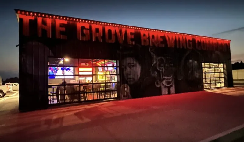 Exterior of The Grove Brewing Co. lit with red roofline Permanent Outdoor Lighting in Oklahoma at dusk