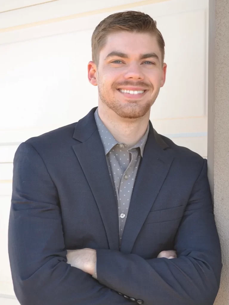 Brilliant By Night founder, Eli, wearing a suit and smiling