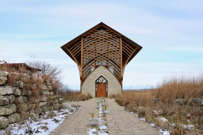 Pathway leads to a small chapel with a wooden lattice roof in nature in Gretna, Nebraska